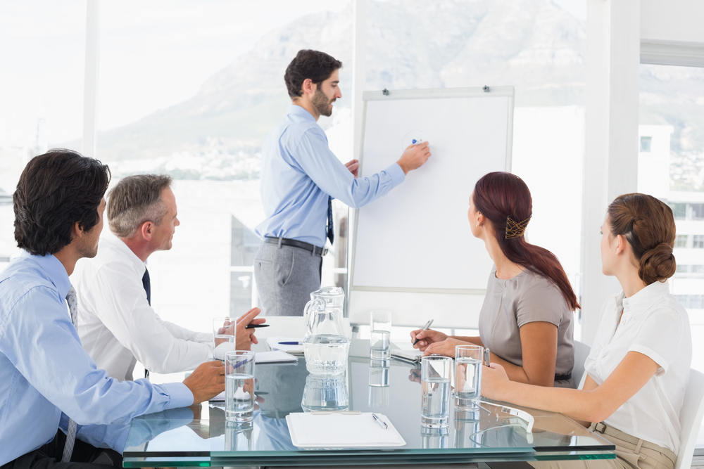 employee writing on a flipchart during a meeting