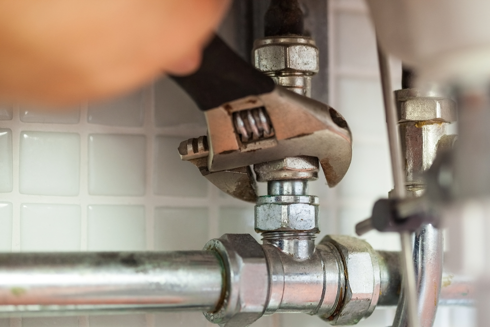 plumber tightening a pipe