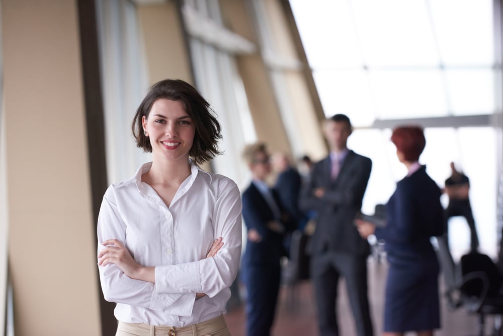 Irish small business owner smiling with colleagues in the background